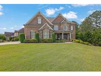 Charming brick home featuring manicured lawn, stone accents, and a meticulously landscaped front yard at 2450 Weber Heights Way, Buford, GA 30519