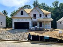 Two-story new construction home with a two-car garage and covered front porch, under construction at 727 Crest Line Trl, Powder Springs, GA 30127