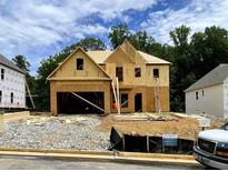 Exterior view of a house under construction with exposed wood framing, a garage, and a yard at 727 Crest Line Trl, Powder Springs, GA 30127