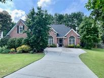 Charming brick home with lush landscaping and an inviting driveway at 1902 Commons View Cir, Snellville, GA 30078