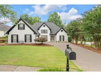 Charming white home with manicured lawn, black shutters, and a long driveway at 530 Georgian Hills Dr, Lawrenceville, GA 30045