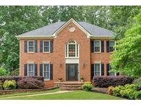 Charming two-story brick home featuring a manicured lawn, elegant landscaping, and classic black shutters at 5804 Fairwood Nw Cir, Acworth, GA 30101