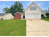 Traditional two-story home with a well-manicured lawn and an attached two-car garage at 1792 Portwest Way, Hampton, GA 30228