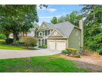 Charming two-story home with a well-manicured lawn, mature trees, and a two-car garage at 11260 Havenwood Dr, Johns Creek, GA 30097