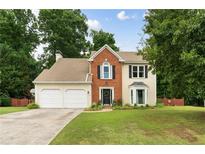 Charming two-story home featuring a well-manicured lawn, brick accents and a two-car garage at 2904 Masonwood Nw Dr, Kennesaw, GA 30152