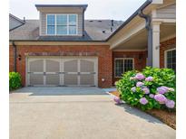 Two-car garage with traditional doors and manicured landscaping at 4347 Lanier Ridge Walk # 1501, Cumming, GA 30041
