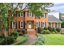 Beautiful two-story brick home with black shutters, a manicured lawn, and a welcoming front entrance at 4497 Windsor Oaks Dr, Marietta, GA 30066