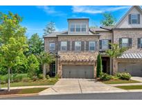 Beautifully landscaped home with stone accents, attached two-car garage, and charming curb appeal at 1099 Heyward Way, Alpharetta, GA 30009