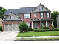 Charming two-story brick home with a well-manicured lawn and a covered front porch at 2555 Blackstock Dr, Cumming, GA 30041