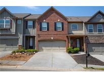 Charming townhome features brick accents, a two-car garage, and a well-maintained front yard in a desirable neighborhood at 3325 Castleberry Village Cir, Cumming, GA 30040