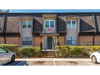 Charming brick townhome with a well-maintained exterior, front yard landscaping, and ample parking at 365 Winding River Dr # E, Atlanta, GA 30350