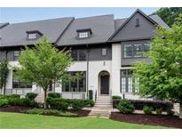 Charming townhouse featuring a landscaped front yard, painted brick, and modern architectural details at 6445 Lucent Ln, Atlanta, GA 30328