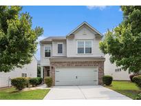 Charming two-story home with a brick facade and manicured lawn at 1295 Aster Ives Dr, Lawrenceville, GA 30045