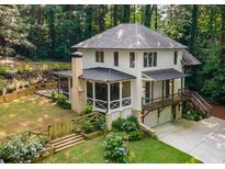 Aerial view of a two-story home with a screened porch, a two-car garage, and beautiful landscaping at 1461 Bubbling Creek Ne Rd, Brookhaven, GA 30319