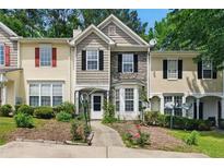 Charming townhome with stone accents, manicured landscaping, and inviting walkway to a cozy front porch at 1689 Camden Forrest Way, Riverdale, GA 30296
