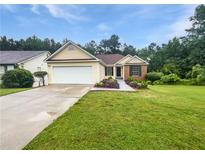 Charming single-story home boasts a well-manicured lawn and a two-car garage at 6560 Alford Way, Lithonia, GA 30058