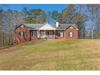 Charming single-Gathering brick home with a well-manicured lawn and inviting front porch at 5826 Little Mountain Dr, Ellenwood, GA 30294