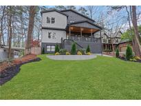 Beautiful two-story home with a covered porch, manicured lawn, and modern gray and white color scheme at 2497 Wawona Dr, Brookhaven, GA 30319