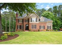 Beautiful two-story brick home with manicured lawn and mature trees in a desirable neighborhood at 6061 Meridian Nw Dr, Acworth, GA 30101