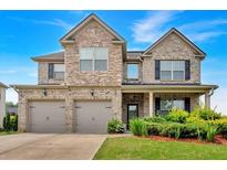 Beautiful two-story brick home with a three car garage and landscaped front yard at 2239 Noelle Pl, Powder Springs, GA 30127