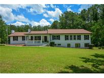 Charming ranch home featuring a welcoming front porch and lush lawn at 871 Cowan Se Rd, Conyers, GA 30094