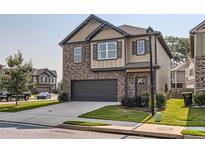 Charming two-story home with brick and siding, showcasing a well-maintained front yard and attached two-car garage at 11910 Brightside Pkwy, Hampton, GA 30228