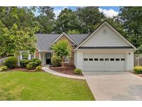 Charming single-story home featuring a well-manicured lawn and an attached two-car garage at 1865 Morgans Run Trl, Buford, GA 30519