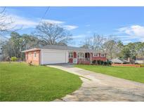 Charming single-story red brick home with attached garage and well-manicured lawn at 2649 Lake Harbin Rd, Morrow, GA 30260