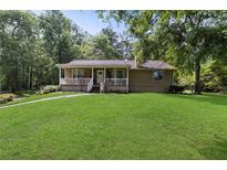 Charming home with a welcoming front porch and a well-maintained lawn and beautiful tree coverage at 6 Water View Dr, Stockbridge, GA 30281