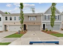 New construction townhomes with brick and siding exteriors, garages and well manicured lawns at 113 Priestwood Ln, Acworth, GA 30102