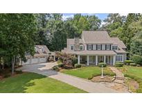 Stately home with a stone driveway and professionally landscaped front yard and a three car garage at 585 Old Cobblestone Dr, Atlanta, GA 30350