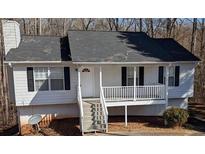 Charming home featuring white siding, black shutters, and a welcoming front porch at 1668 Independence Dr, Douglasville, GA 30134