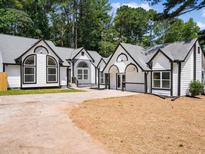 Charming home featuring black trim, arched windows, and a freshly landscaped yard with a large driveway at 3100 Mount Gilead Sw Rd, Atlanta, GA 30311