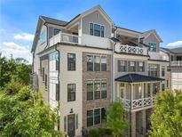 Stunning townhouse with a brick facade and multiple balconies, surrounded by lush greenery at 343 Concord St, Alpharetta, GA 30009
