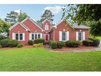 Charming single-story brick home with manicured lawn, trimmed hedges, and white shutters at 4440 Weston Sw Dr, Lilburn, GA 30047