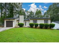 Charming single-story home featuring a well-maintained lawn and attached garage at 1070 Salisbury Trl, Riverdale, GA 30296