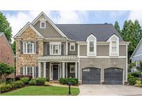 Charming home featuring stone and shingle siding, a manicured lawn and an attached two-car garage at 1075 Bluffhaven Way Northeast Ne Way, Atlanta, GA 30319