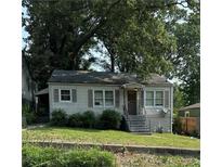 Charming single-story home with gray exterior, shuttered windows, and a front porch, surrounded by mature trees at 213 Birch St, Hapeville, GA 30354