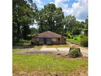 Charming stone home with a unique, rustic exterior and mature trees surrounding the property at 3547 Pleas Dr, Ellenwood, GA 30294