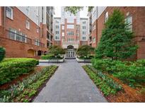 Beautiful courtyard of a brick apartment building with landscaped flower beds and walkway to the main entrance at 50 Biscayne Nw Dr # 4110, Atlanta, GA 30309