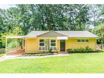 Charming brick home with well-manicured lawn, mature trees, and inviting carport at 3467 Pinehill Dr, Decatur, GA 30032