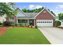Charming brick home featuring a manicured lawn and a two-car garage at 4178 Mcever Park Dr, Acworth, GA 30101