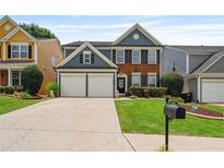 Charming two-story home featuring a brick facade, blue siding, a well-manicured lawn, and a two-car garage at 4312 Shillham Ct, Cumming, GA 30040