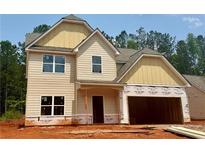 Two-story home featuring a two-car garage and partially completed exterior with beige siding at 484 Charleston Pl, Villa Rica, GA 30180
