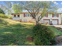 Charming home featuring a well-maintained yard, red shutters and two-car garage at 945 Blackwell Rd, Marietta, GA 30066