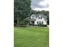 Charming home with lush green lawn, mature trees and manicured landscaping at 9707 Squirrel Wood Run, Douglasville, GA 30135