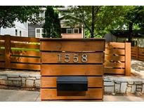 Stylish home address on a wood post, complemented by a wood fence and stone base at 1558 Line St, Decatur, GA 30032