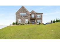 Charming two-story brick home with well-manicured lawn and inviting curb appeal at 1604 Falcon Ct, Locust Grove, GA 30248