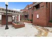 Brick condo building with a manicured courtyard entrance, featuring planters and a white pergola at 387 Ralph Mcgill Ne Blvd # K, Atlanta, GA 30312