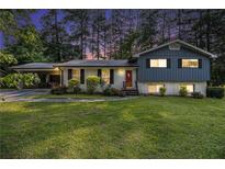 Charming two-story home with a well-manicured lawn and a covered carport at 6085 Dunbritan Ln, Atlanta, GA 30349